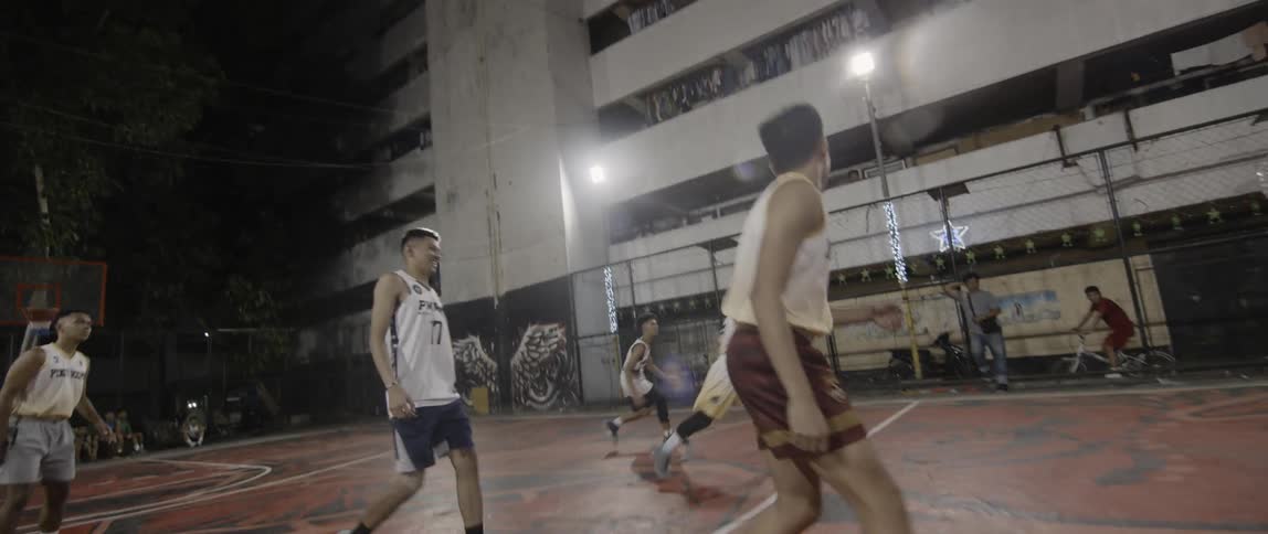 Men play basketball on an outdoor court