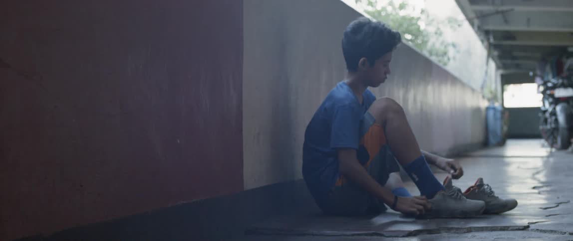 A young boy ties his shoes