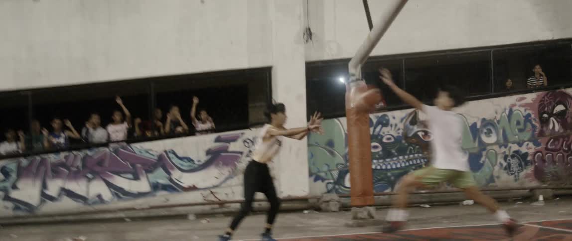Boys play basketball on an outdoor court