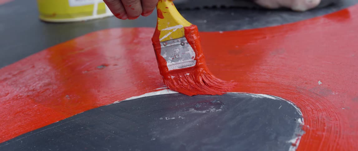 Man paints on concrete ground