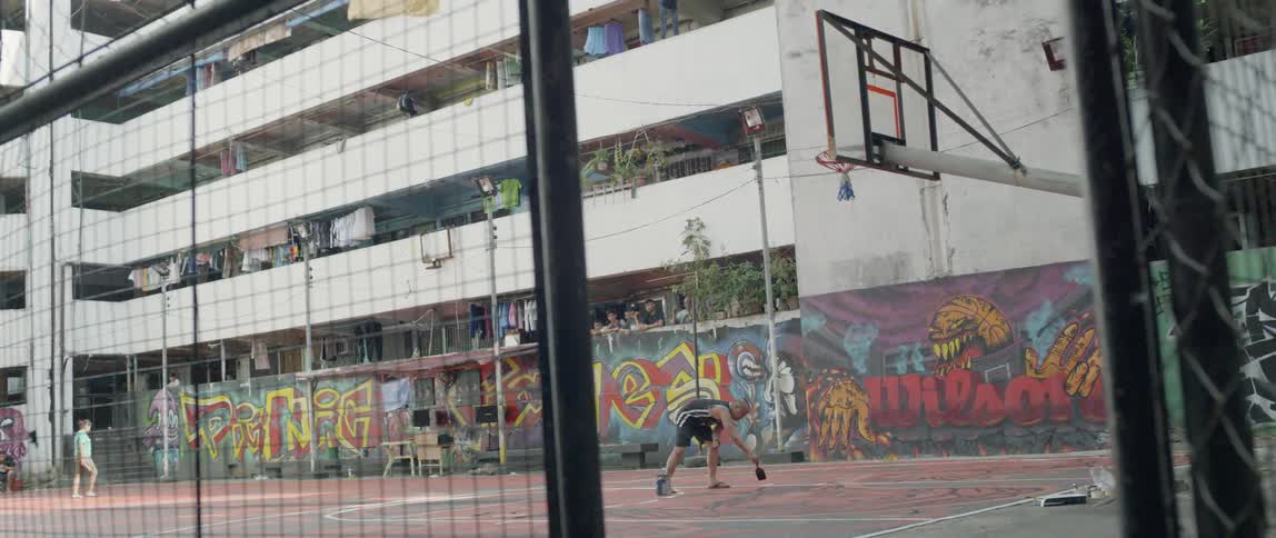 Man paints fresh lines on a basketball court