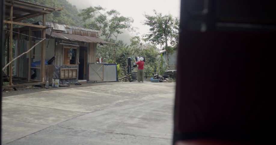 Woman hangs clothes on a line next to a building