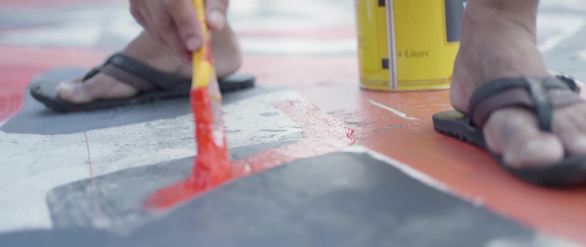 Man paints a red line on the floor