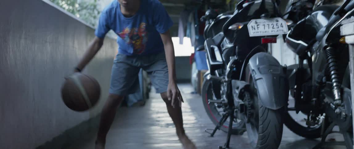 Boy dribbles a basketball on concrete