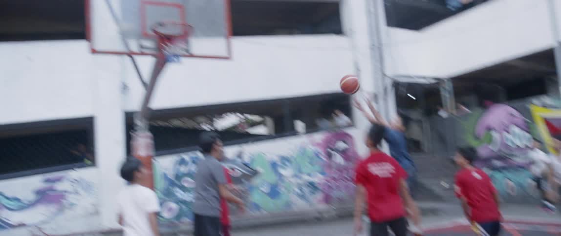 Boys play basketball on an outdoor court