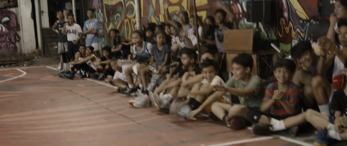 The people sit on the side of the court and cheer
