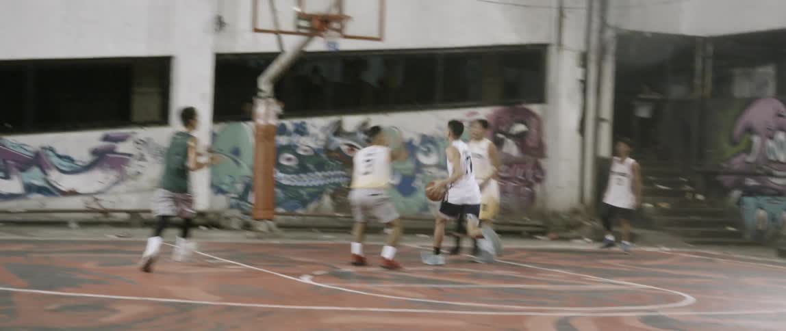 Men play basketball on an outdoor court