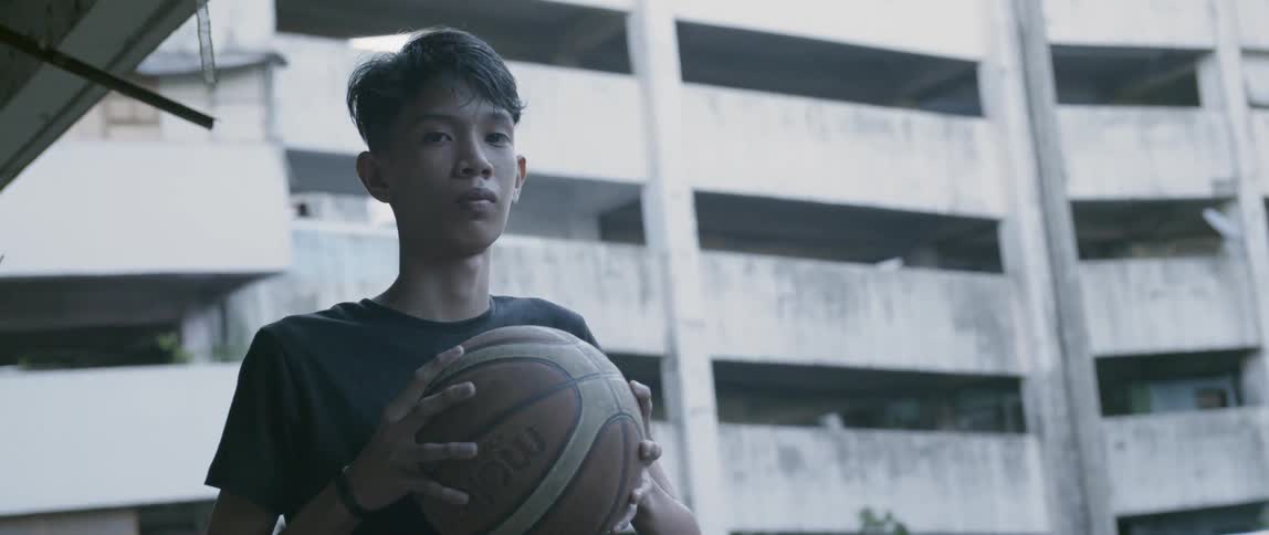 Teenage boy holds a basketball