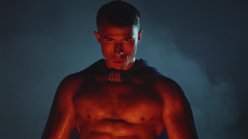 A gladiator stands near a fire