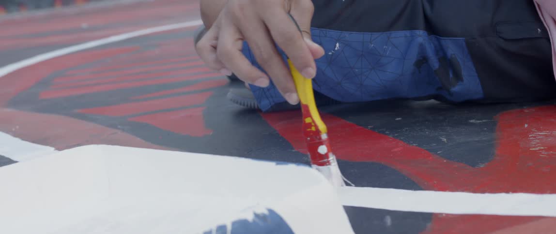 Man paints a white line on the floor