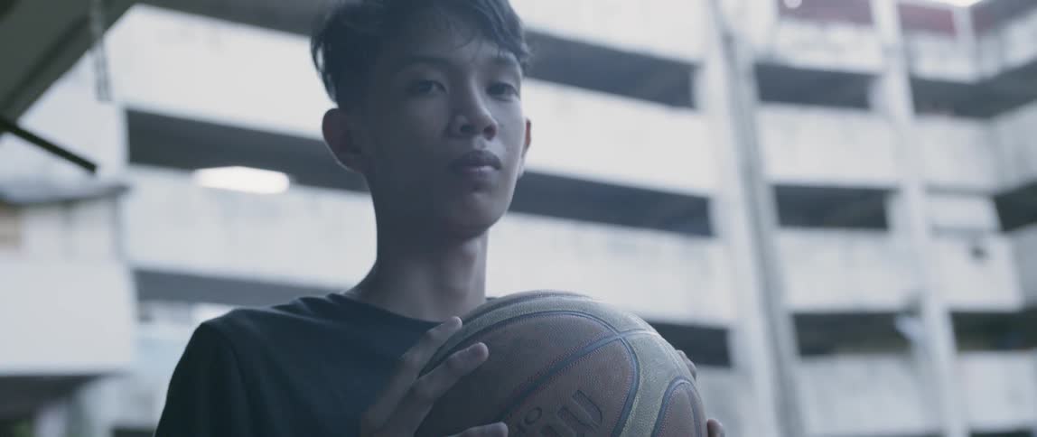 Boy holds a basketball at an apartment complex
