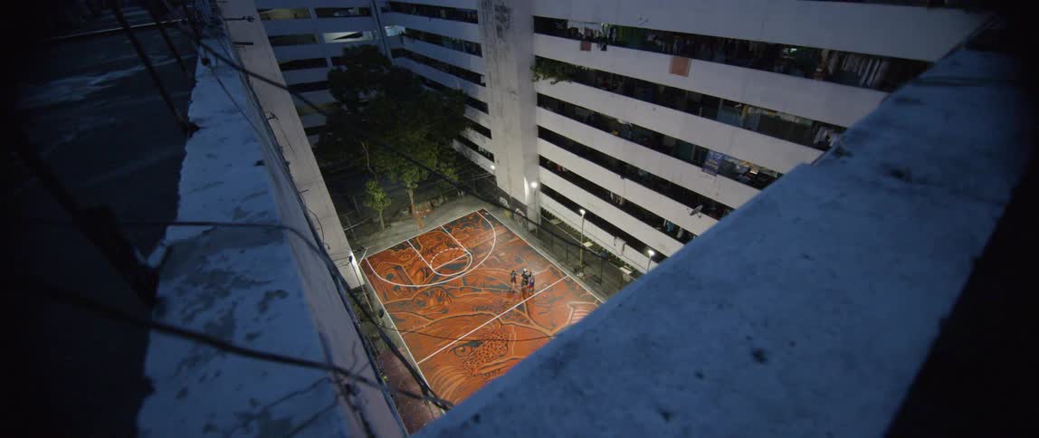 Trees and a basketball court in an apartment building courtyard