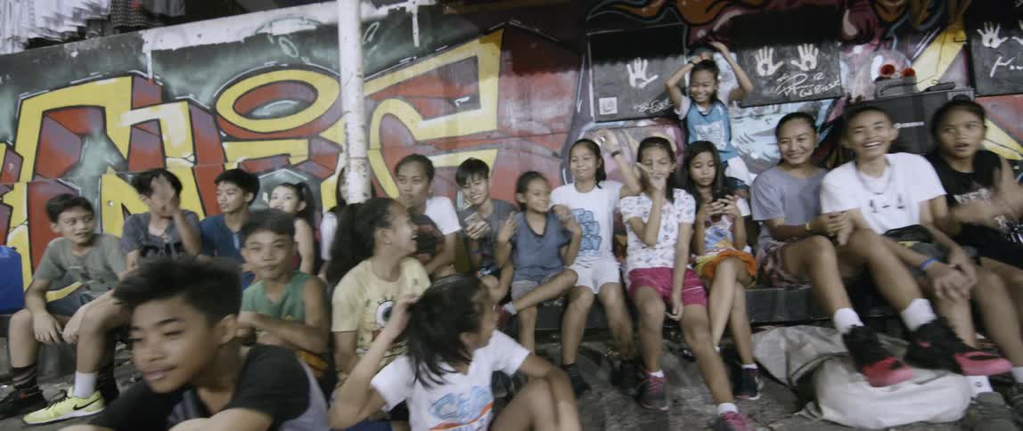 Children cheer and clap as they watch a basketball game