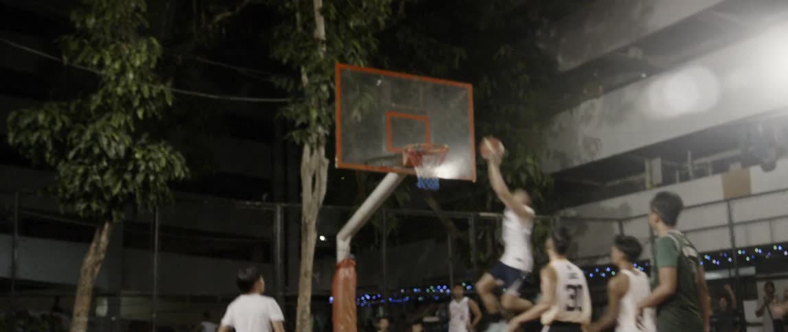 Boys play basketball on an outdoor court