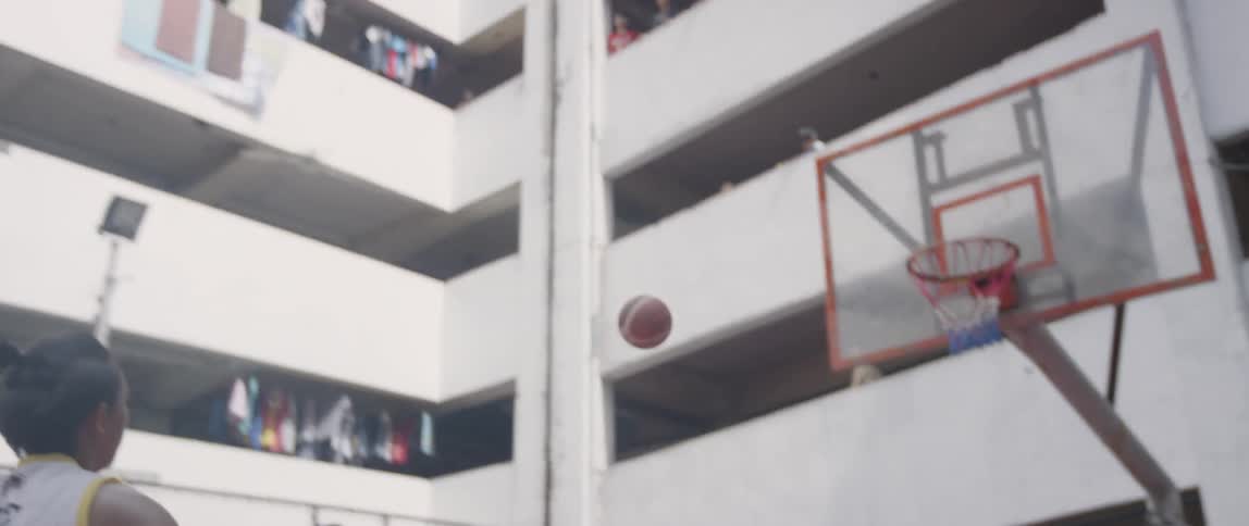Boys play basketball on an outdoor urban court