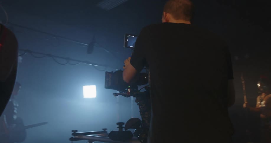 A camera crew films a gladiator in a studio
