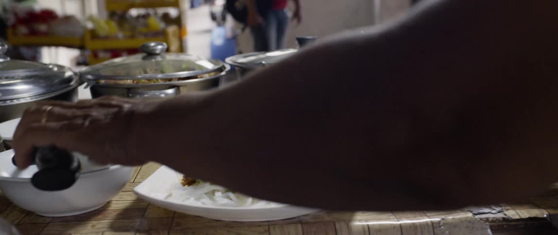 A person prepares a dish and lifts it up