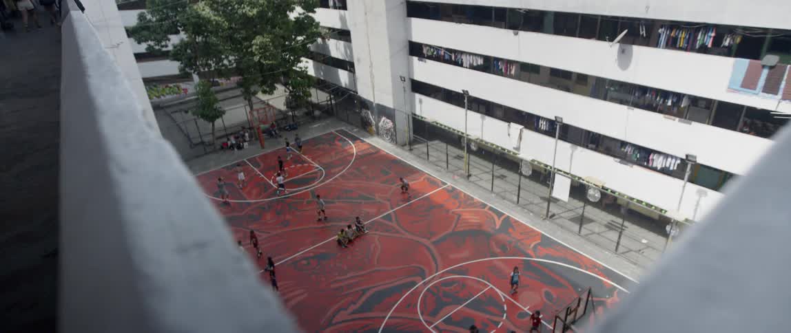 A basketball court sits in an apartment courtyard
