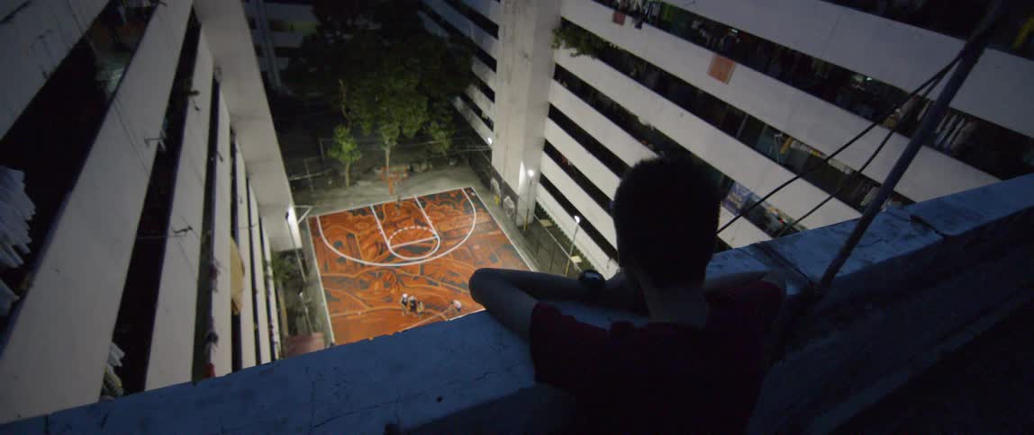 A young man looks down on a basketball court