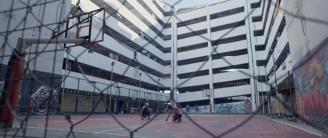 A basketball court sits in an apartment courtyard