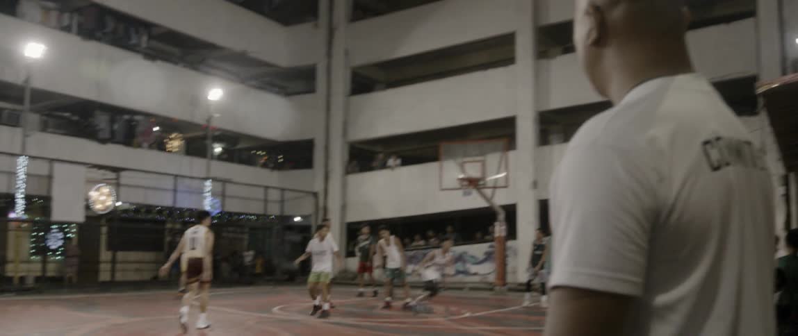 A man watches as young basketball players play