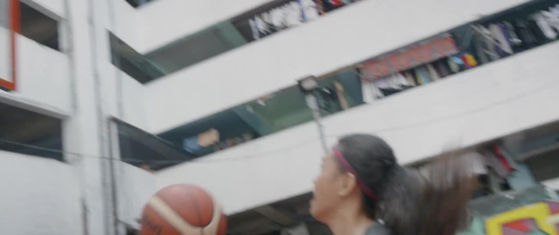 Girl shoots a basketball into a hoop