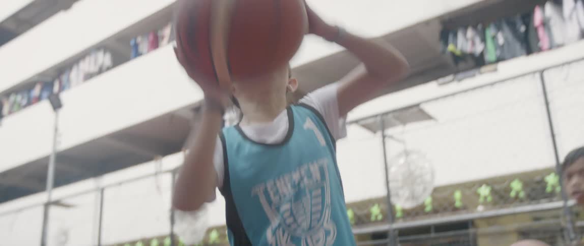 Young girl bounces a basketball and tosses it at a hoop and misses