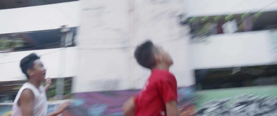 Boys play basketball on an outdoor court