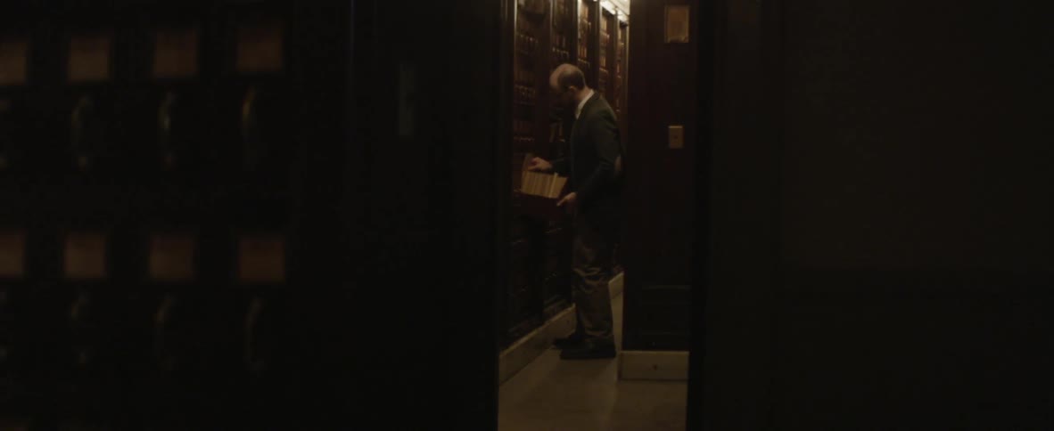 Man searing in a library looking through shelves