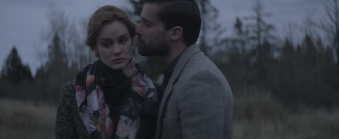 Man kisses a woman on the face on a cloudy day