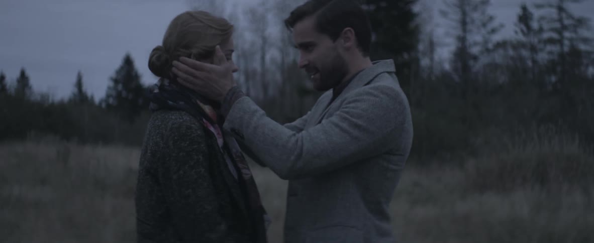 A man kisses a woman on the forehead