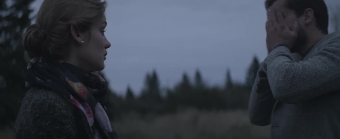 Upset man and woman standing in a field on a overcast day
