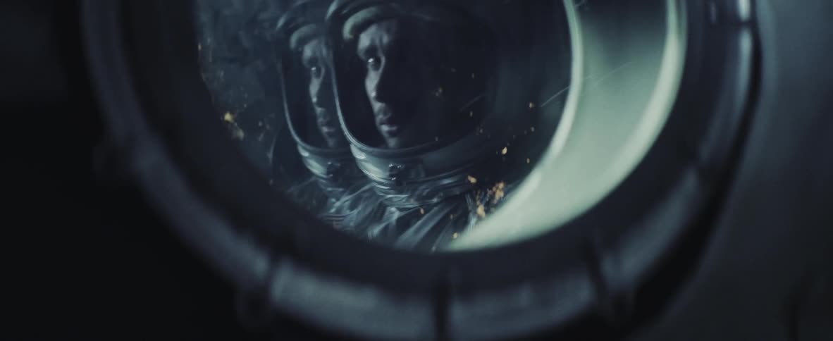 Astronauts looking out of a small round window