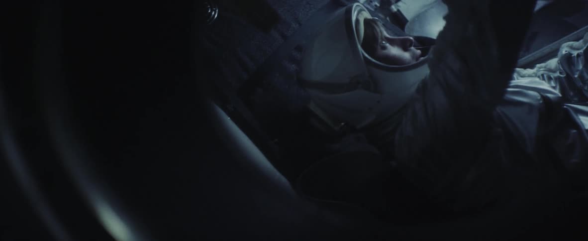 Man wearing astronaut uniform leans forward