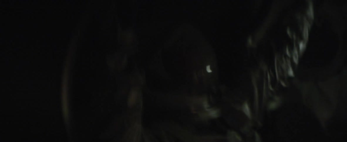 An astronaut is vibrating in his seat and he is holding on to the handles as he begins to panic and puts down his helmet cover and a red light shines on him