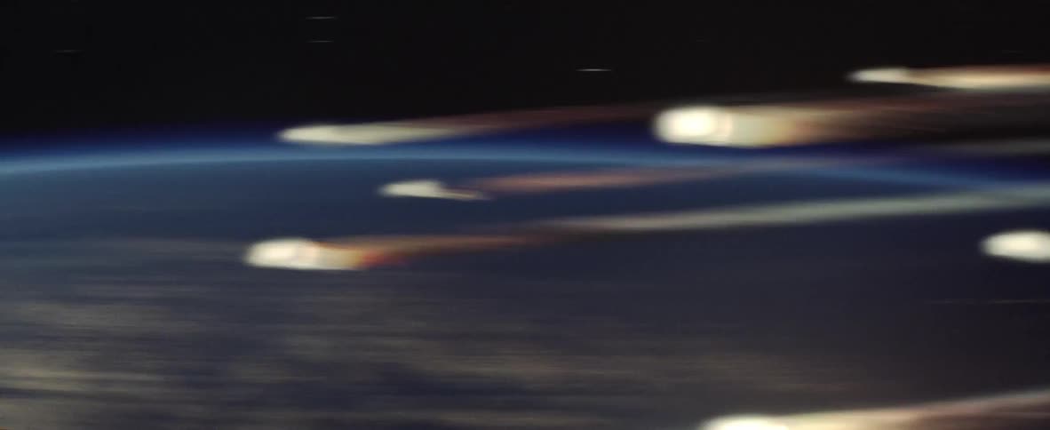 Small meteors bursting into flame as they shoot past