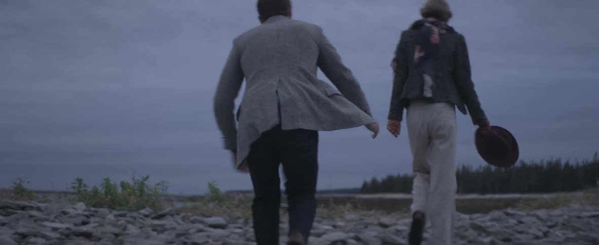 Man and woman are walking outdoors and holding hands