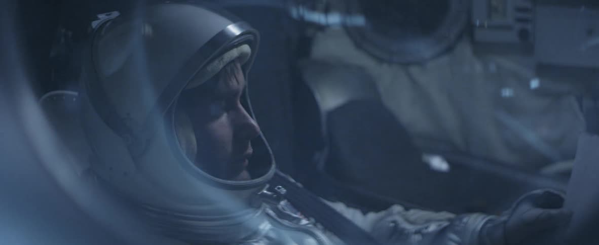Man wearing an astronaut suit sitting in a pod