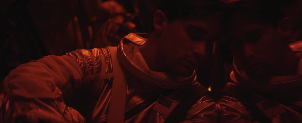 Man sitting in a dark area wearing a uniform