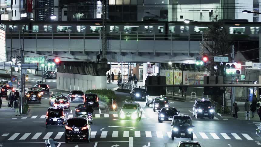 Vehicles and pedestrians commute in the city at night