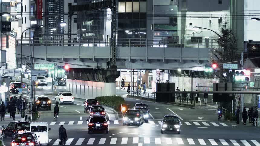 Cars drive on a city street at night