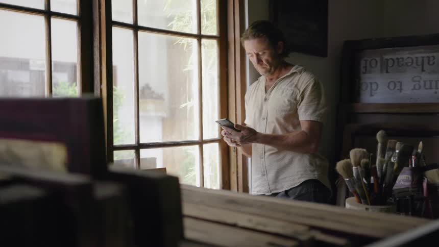 Man looks at his phone in an art studio