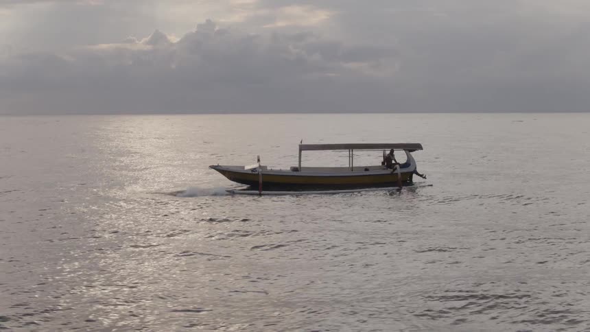 Swimmers jump from a boat into ocean water