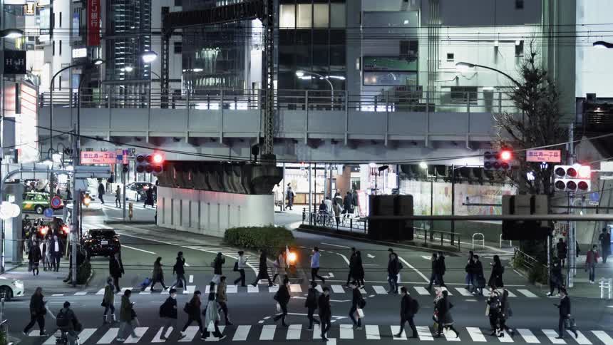 Pedestrians cross the street as vehicles travel nearby