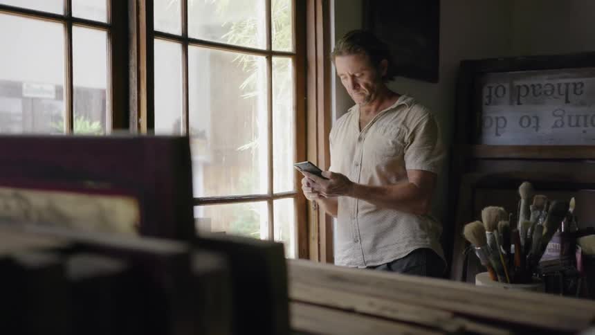 Man looks at his phone in an art studio