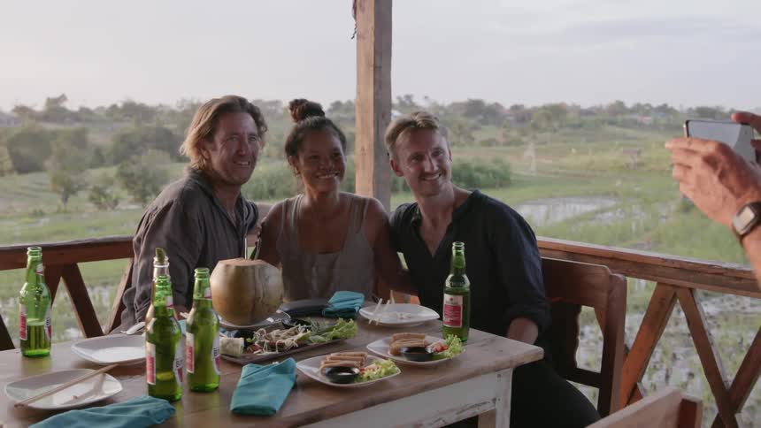 Friends pose for a picture while dining on a patio