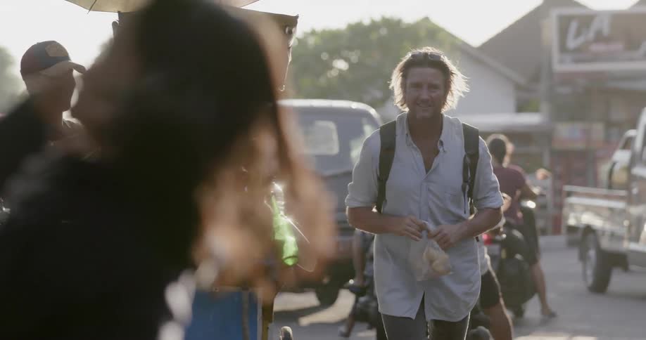 A man buys some food from a street vendor
