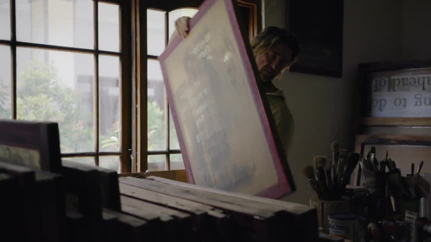 Man picks up a large piece of canvas and walks away
