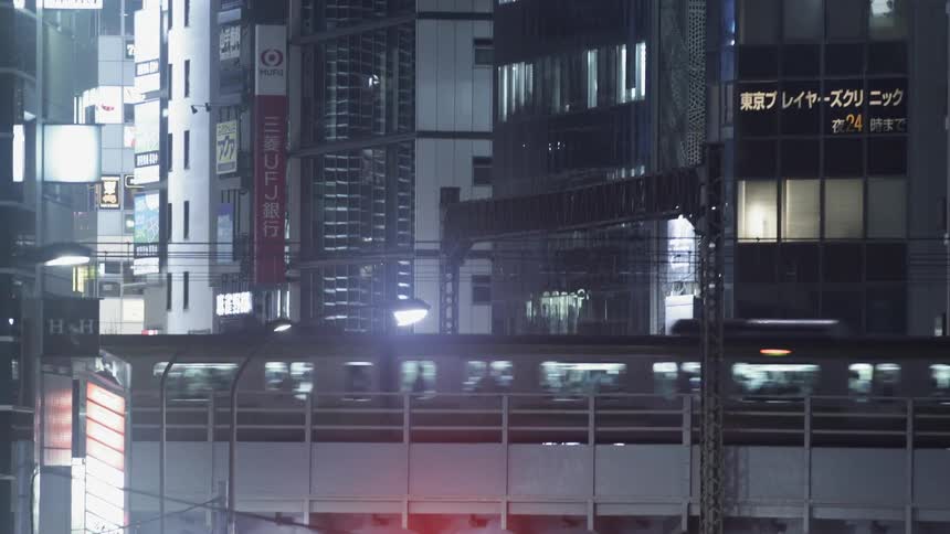 An elevated train travels through a city at night