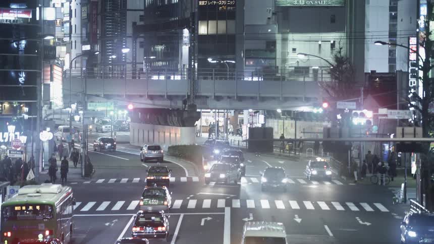 Vehicles on a busy city street lit up at night